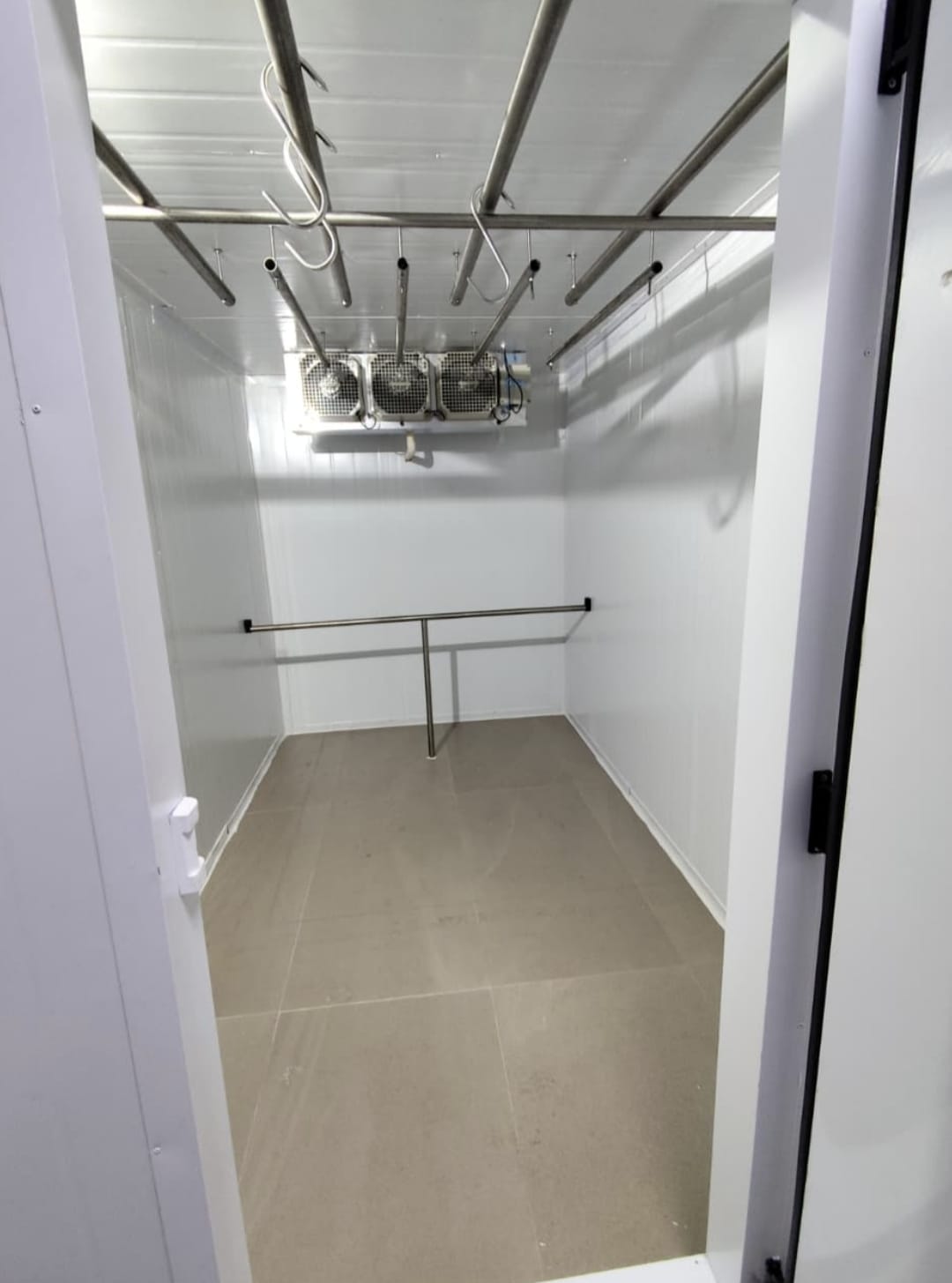 Walk-in cooler com estrutura interna para armazenamento.